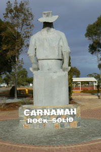 Sculpture depicting a farmer with a sack of grain. 'Carnamah, Rock Solid' is written on the base