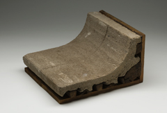 Curved, moulded concrete brick on a wooden mould