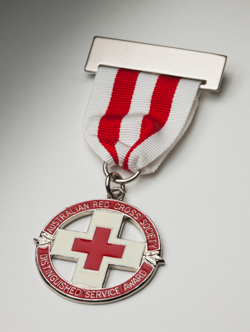 A Red Cross badge hanging from a silver bar and a ribbon with vertical white and red stripes. The circular award features a central red on cross on silver background, with the words 'AUSTRALIAN RED CROSS SOCIETY / DISTINGUISHED SERVICE AWARD' on an outer circle.