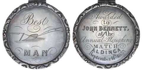 Image showing two faces of a circular medallion with a ring at the top. The face on the left is inscribed 'Best MAN' with an image of a plough. The right is inscribed with 'Awarded/to/John Bennett/at the/Annual Ploughing/Match/Aldinga/September 14th 1853'.