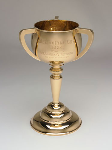 Three-handled gold cup engraved with 'MELBOURNE CUP, 1934, won by Mr RR Dangar's Peter Pan, age 5 yrs. Weight 8st 10lb'.