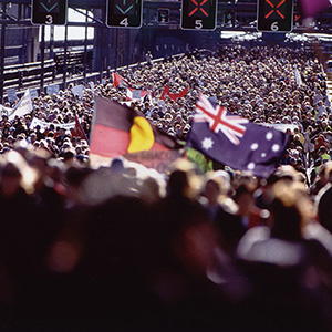 Crowd on bridge with flags