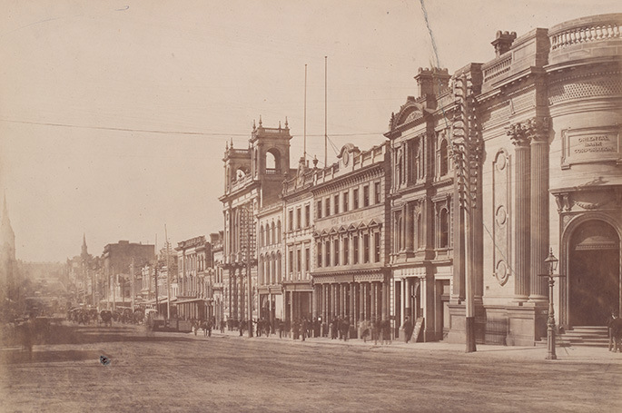 A series of two or three storey buildings with a street that appears to be dirt