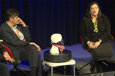 Image still of three people on stage in a panel arrangement