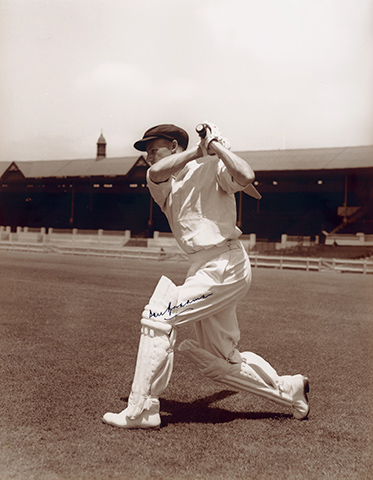 Batsman hitting ball, with stadium in background