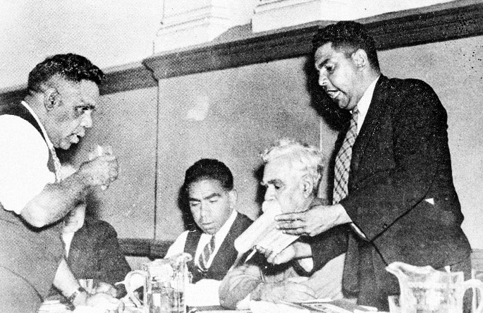 Interior photo of Four Aboriginal men – two standing and two sitting