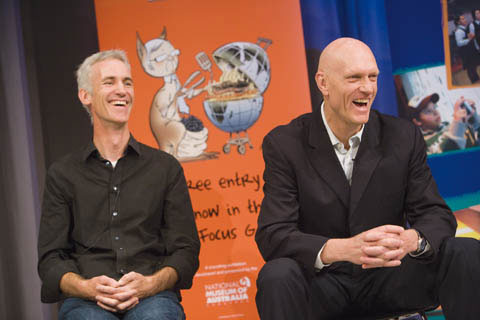 David Pope and Peter Garrett sit laughing, with crossed hands, in front of a banner showing a caricature of Kevin Rudd as a kangaroo, barbecuing an Australia-shaped steak.
