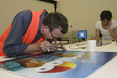 Conservation Manager Eric Archer assesses the condition of the first painting recovered from the site, whilst Exhibitions Manager Stephanie Magri-Bull liaises with recovery team members.