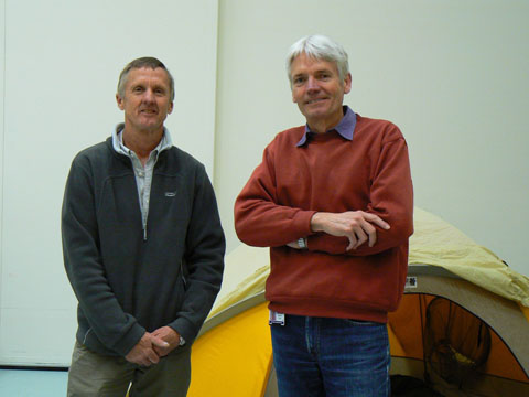 Geoff Bartram and Matthew Higgins stand in front of a yellow tent.