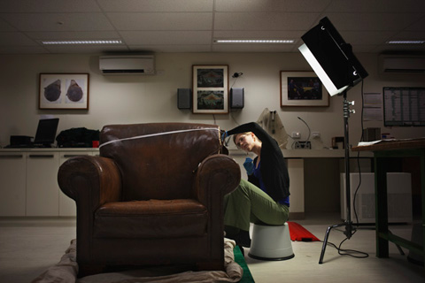 Conservator, Melanie Forward, restitching the right shoulder of the chair.