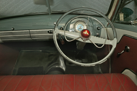 Interior view of the FJ featuring the dashboard, steering wheel and red leather upholstery.