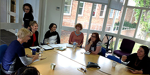 A group of adults sitting around a table in a light-filled room