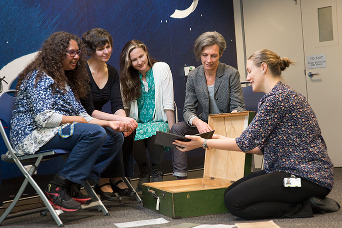 A group of women looking at a museum object.