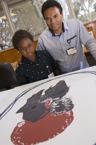 Man with boy inspecting artwork