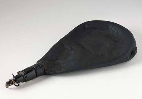 Tear-shaped water bottle of hardened leather with a cylindrical horn lid.