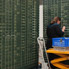 A photograph of a trading board with lists of stock prices and their codes, written in chalk.