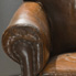 The chair before conservation treatment showing damage to the seat, arm rests and sides.
