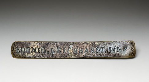 Front view of the Leichhardt nameplate which is a piece of brass 15 cm x 2 cm marked LUDWIG. LEICHHARDT. 1848