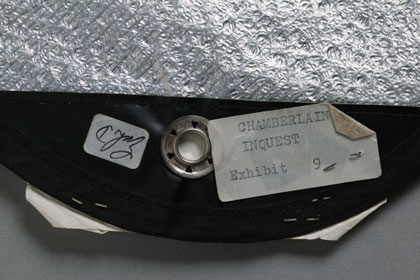 Part of a silver space blanket with a sticker reading 'Chamberlain inquest, exhibit 9'.