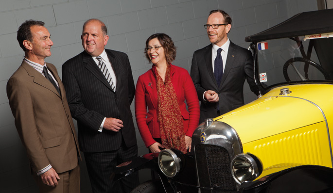 The Executive of the National Museum of Australia standing beside a vintage car.