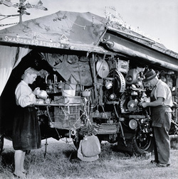 A black and white photograph of Harold Wright and his daughter Evelyn with the Saw Doctor's Wagon, 1956.