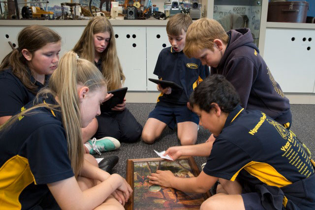 A small group of children sitting on the floor and participating in an activity.