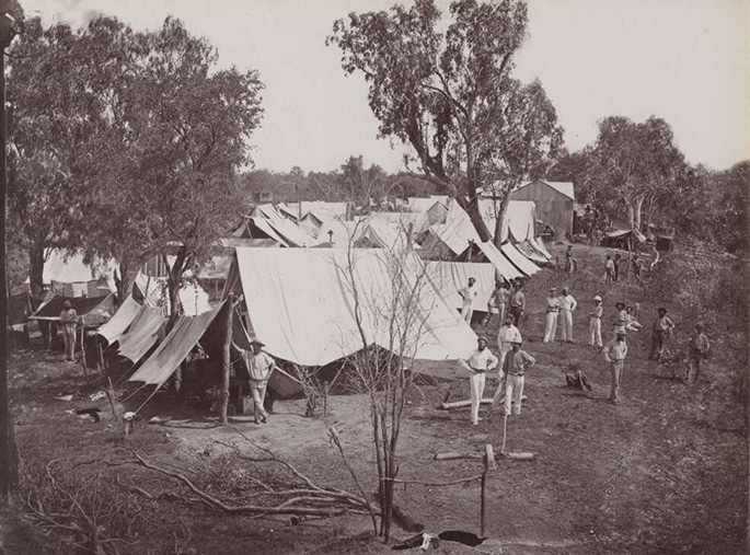 A black and white photo taken in the 1870s of a campsite