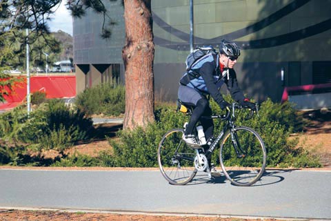 A man rides his bike on a path outside the National Museum.