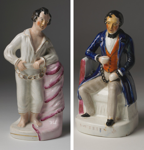 Left: Ceramic figurine depicting a man standing bare foot and leaning against a post draped with pink fabric. The man has short brown hair, is clean shaven and wears an open-necked white shirt and three-quarter length white pants. His wrists are chained with manacles, which are decorated with gold. Right: Ceramic figurine depicting a man sitting on a seat. The man has short brown hair, is clean shaven and wears a blue three-quarter length coat, an orange waistcoat, beige trousers, black shoes and a black cravat. His wrists are chained together with manacles, which are black in colour. The name 'S. O'Brien' is shown on the base of this figurine.