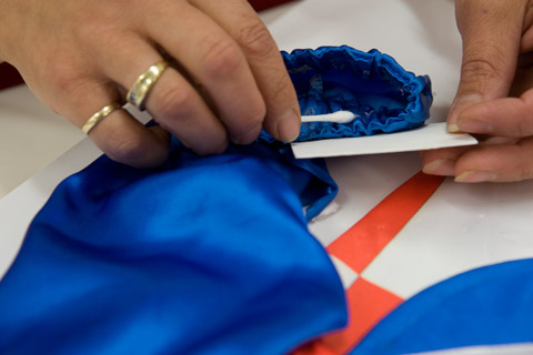 Removing the double-sided adhesive residue from the sleeve cuff.