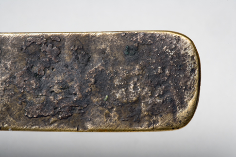 Close up image of an end section of the Leichhardt nameplate detailing the greyish-brown uneven surface.