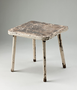 Wooden stool, painted cream, with four legs and a square seat.