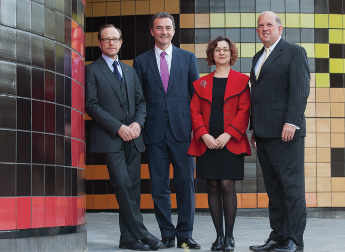 Four members of the Museum's Executive, standing in front of a tiled wall, from left: Director, Andrew Sayers; Assistant Director, Mathew Trinca; Assistant Director, Helen Kon; and Chief Operating Officer, Graham Smith.