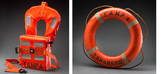 Orange lifejacket; orange lifebuoy with ‘Tampa’ painted on it.