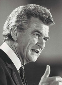 Black and white three-quarter profile photo of Hawke speaking publicly