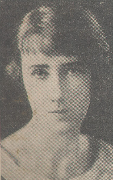Photograph of a dark-haired woman gazing, unsmiling, at the camera