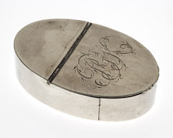Oval-shaped silver snuffbox with intials PGK engraved on top.