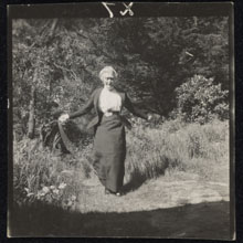 Black and white photograph of Daisy Bates skipping in a garden.