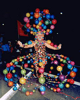 Man wearing flamboyant dress made up of colourful globes