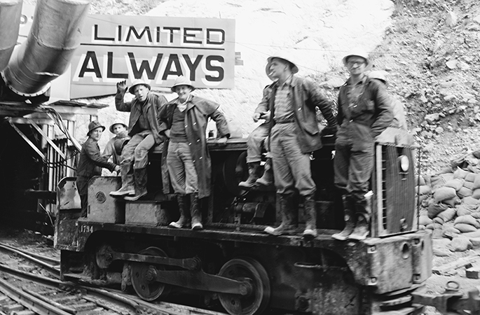 Photo of men riding rail truck entering or exit a tunnel at the Snowy Hydro