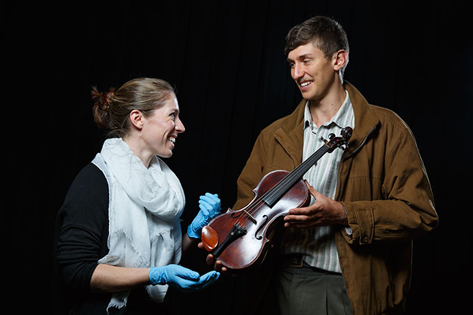 Woman and man inspecting a violin