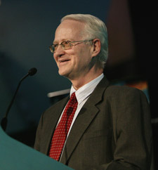 Mr Martin Lutz standing at a podium and speaking into a microphone.