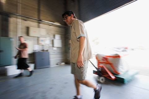 Steven and Carlos move the chair into the Museum's conservation freezer.