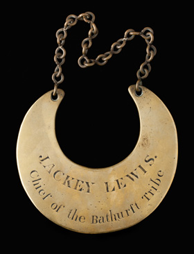 A gold crescent-shaped gorget imprinted with the words 'JACKEY LEWIS, Chief of the Bathurst Tribe'.