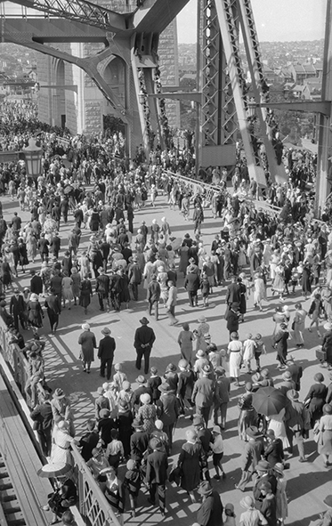 High shot showing hundreds of people crossing the road deck.