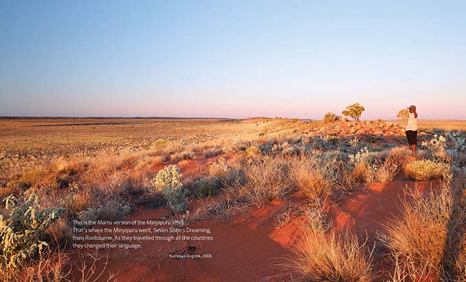 Songlines catalogue spread with a quote from Kumpaya Girgirba and a large desert landscape image