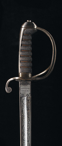 Detail shot showing the top section of a steel sword, with the hilt and part of the blade visible.