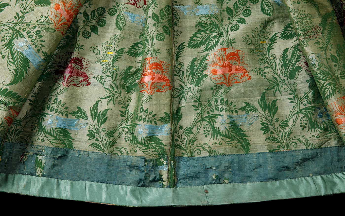 A detail image of the hem of a green and floral dress. - click to view larger image