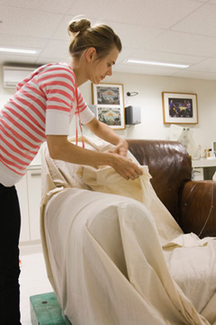 Melanie Forward unwrapping the calico cover from the chair.