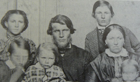 Black and white portrait showing a man and woman and five children.